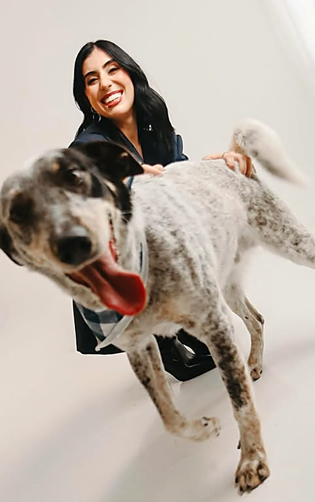 Mulher correndo com o cachorro em ensaio de estúdio